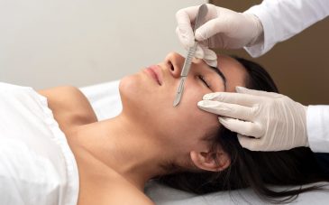 young woman on a table in a beauty center performing a beauty treatment for facial skin with the dermaplaning technique